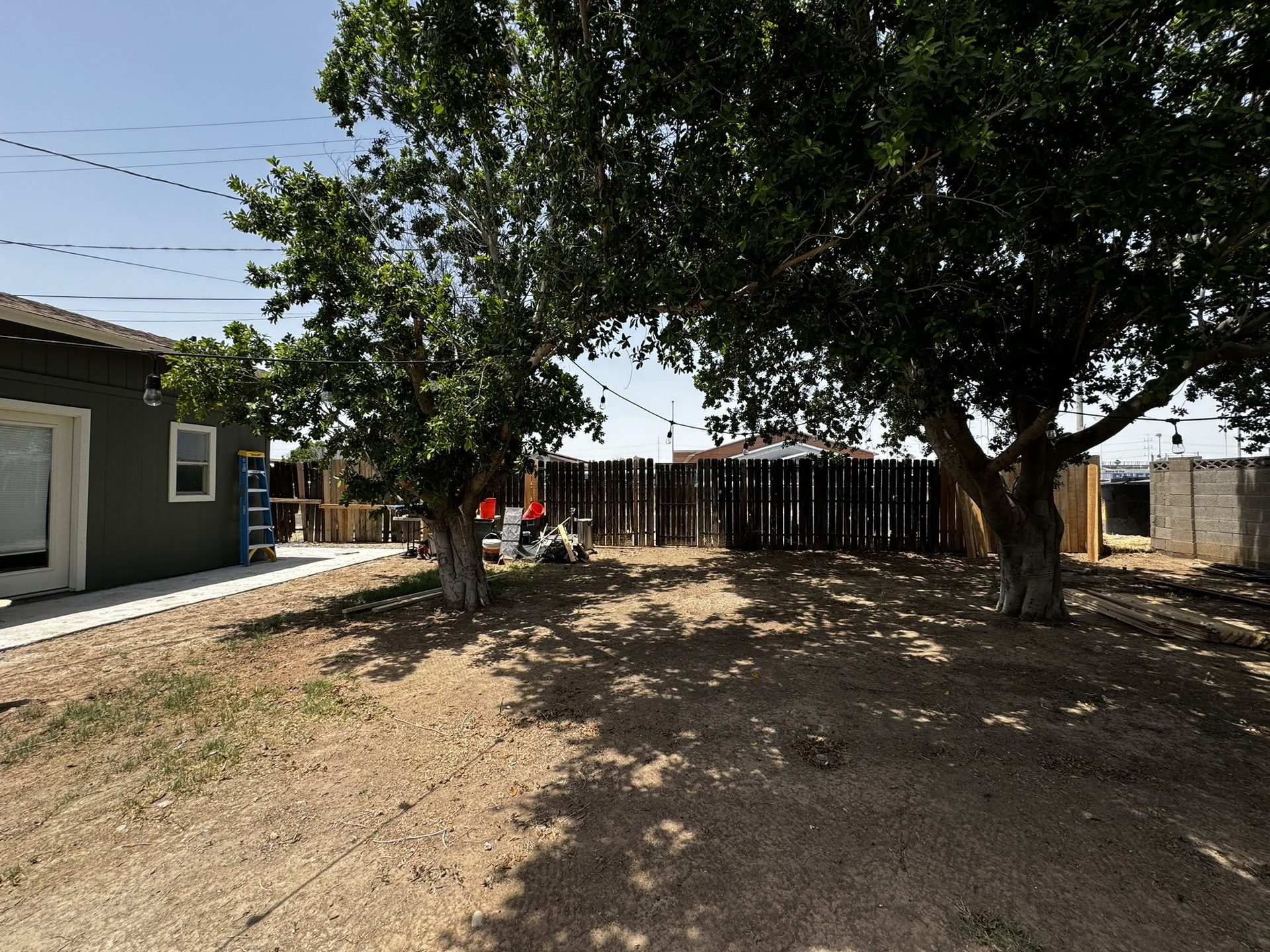 Old leaning wood fence along a backyard alley in Tempe before replacement