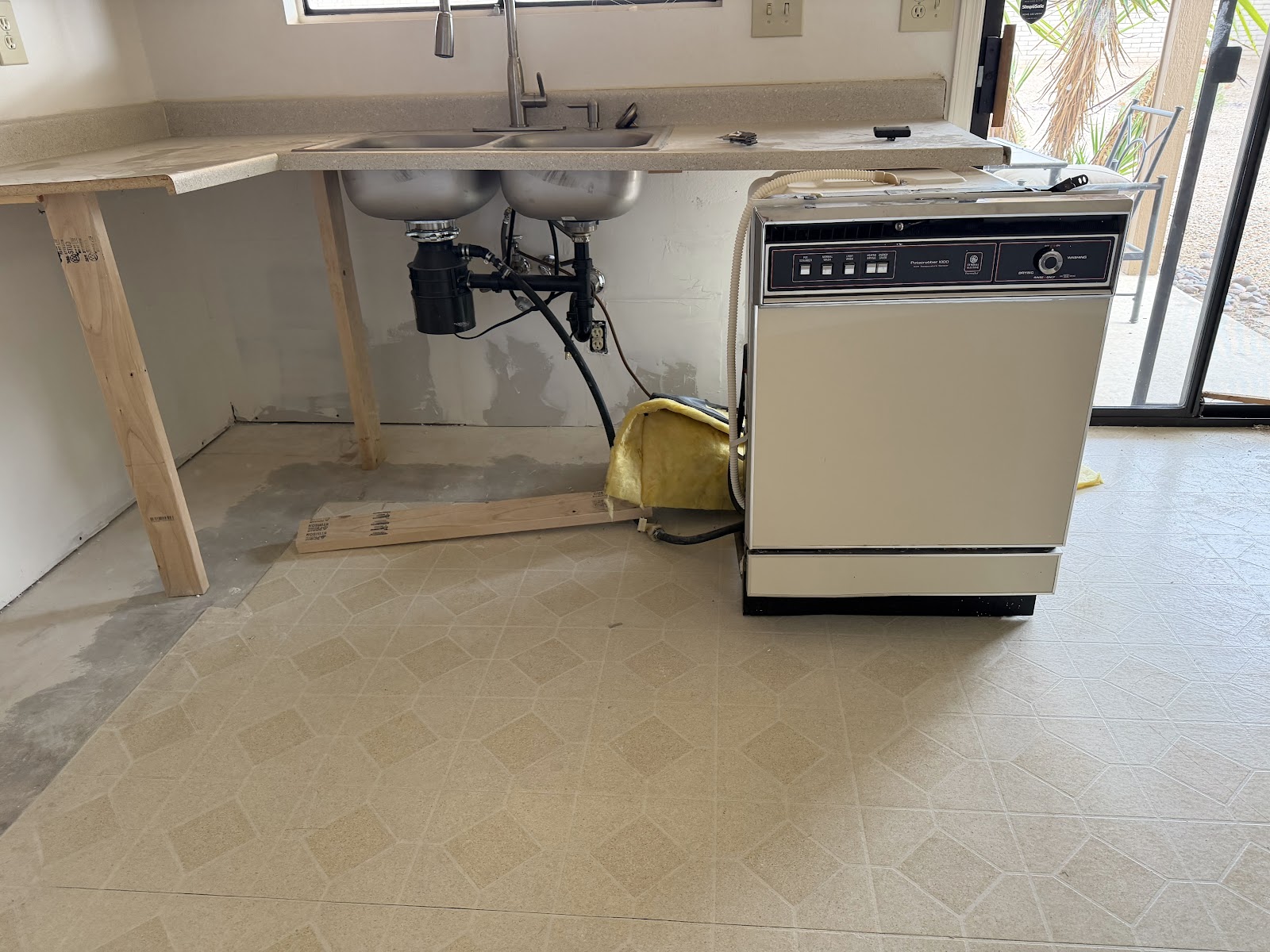 Laminate countertop supported on 2x4 legs so the sink and disposal stayed connected during cabinet demo
