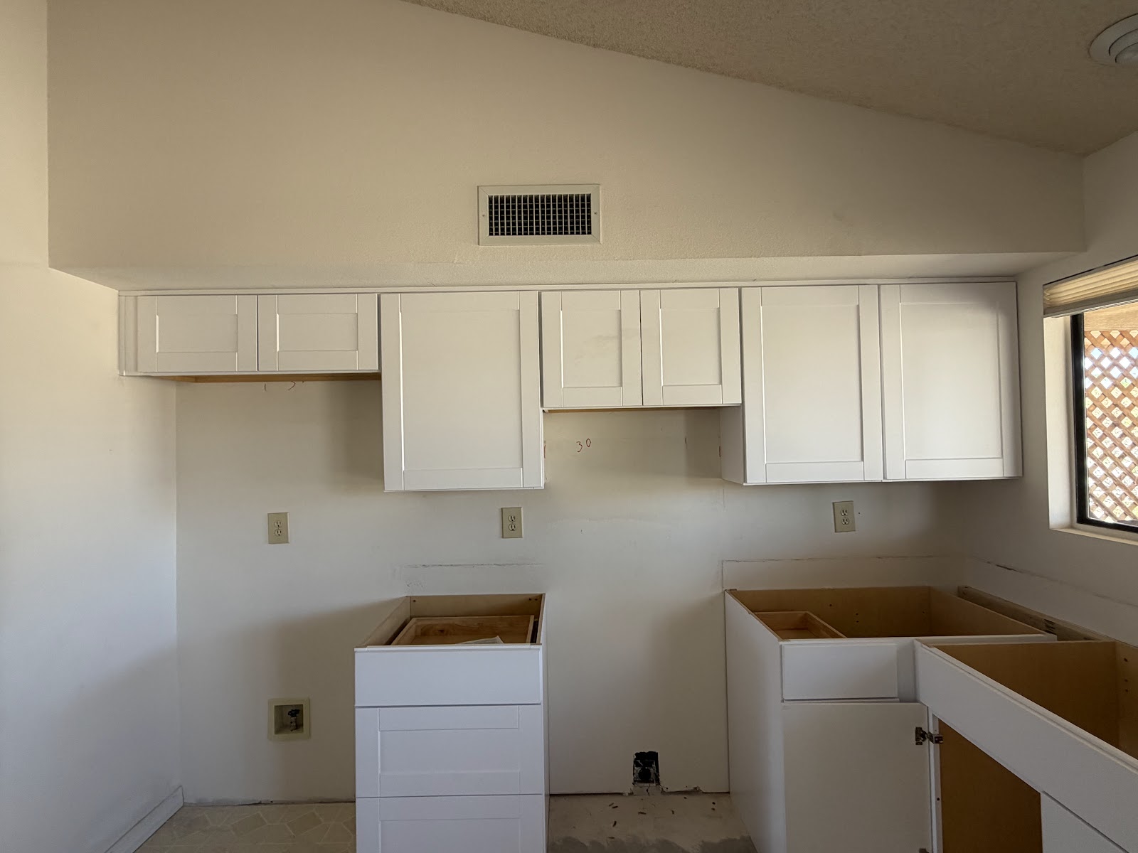 White Shaker uppers with doors on and a 30 inch range hood opening in a Sun City West kitchen