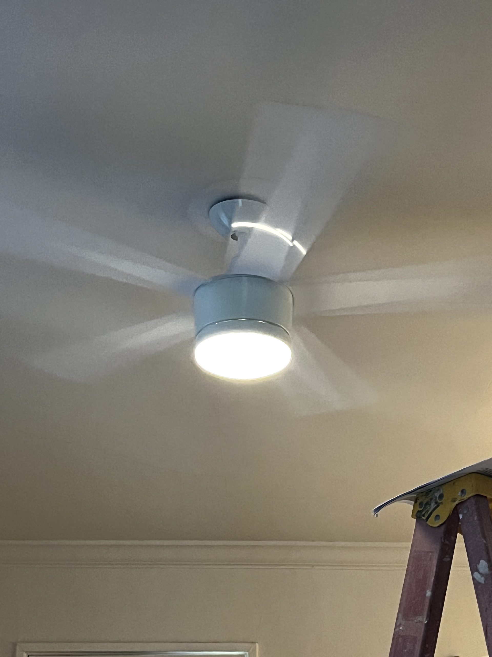 New ceiling fan running with its LED light on after installation in a Phoenix bedroom
