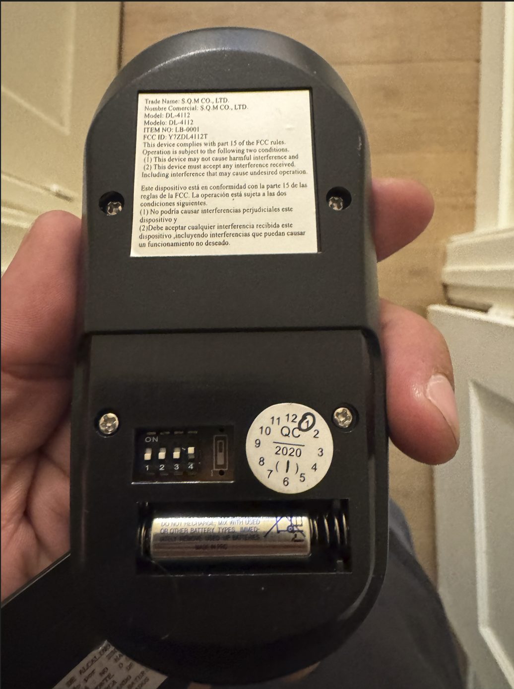 Back of a ceiling fan remote showing the 4-position DIP switch block used to set a unique code