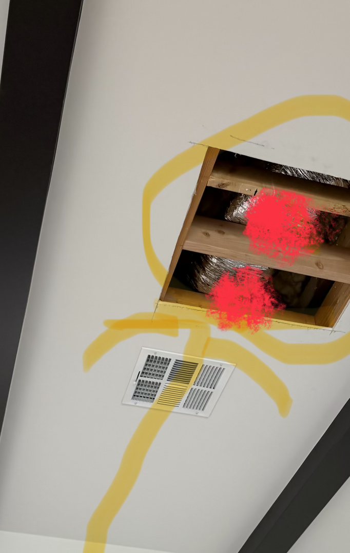 Vaulted ceiling opened between faux beams in a central Phoenix dining room, showing insulated flex duct marked in red at the chandelier mounting point