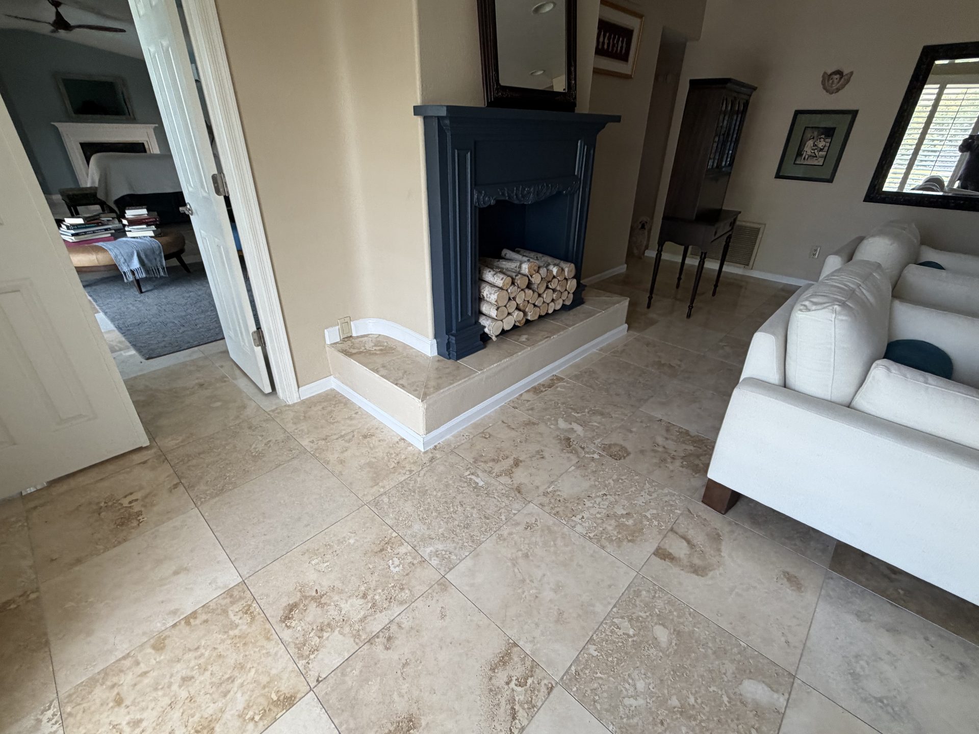 Wood-burning fireplace with a painted surround and travertine hearth in a Scottsdale living room