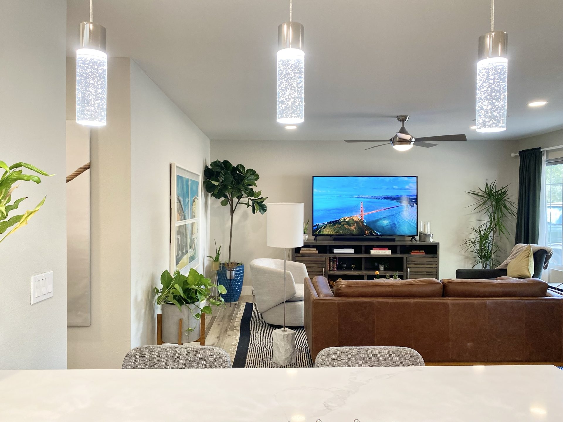 Flower Main House short-term rental in Phoenix: view from the quartz kitchen island across the open-plan living room, with seeded-glass pendant lights over the counter