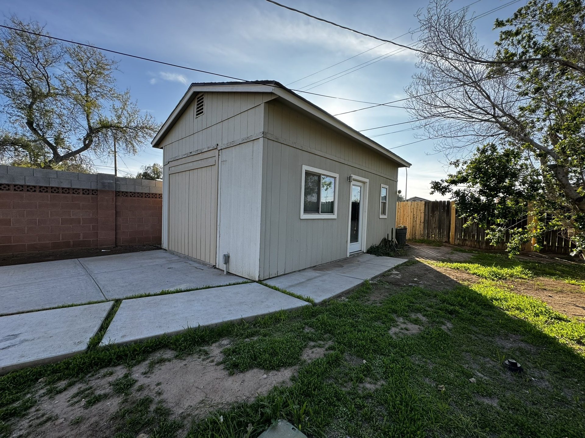 Guest house with dated beige wood siding before repainting in Tempe
