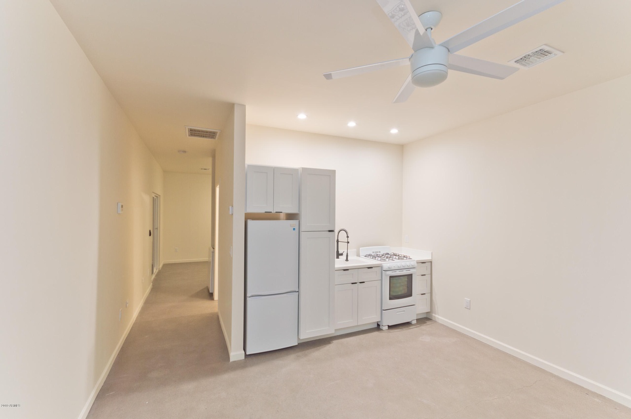 Kitchenette in a Phoenix guest house with a compact gas range, sink, refrigerator and pantry cabinet