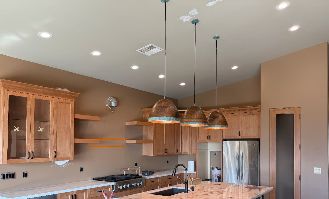 Kitchen built by Norem Contracting in the Phoenix metro: cherry cabinetry, a stone island, copper pendants and recessed lighting