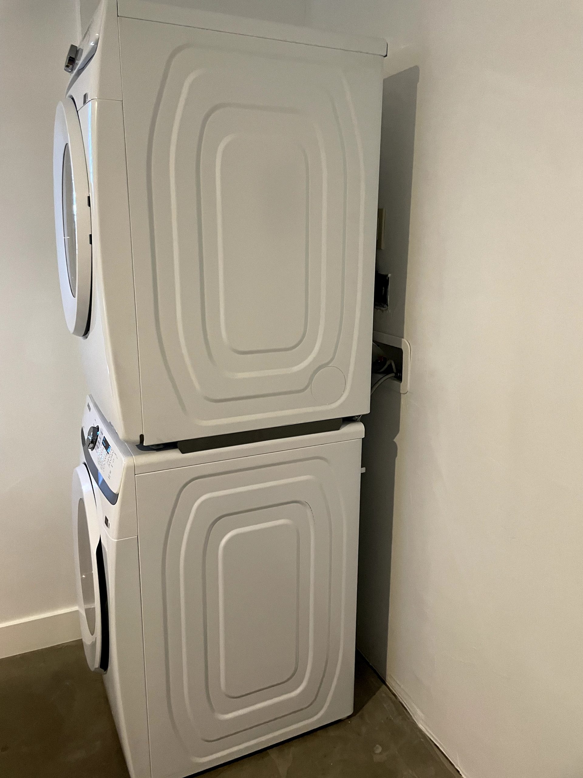 Finished laundry alcove with a stacked washer and dryer, converted from a bedroom closet in a Phoenix home