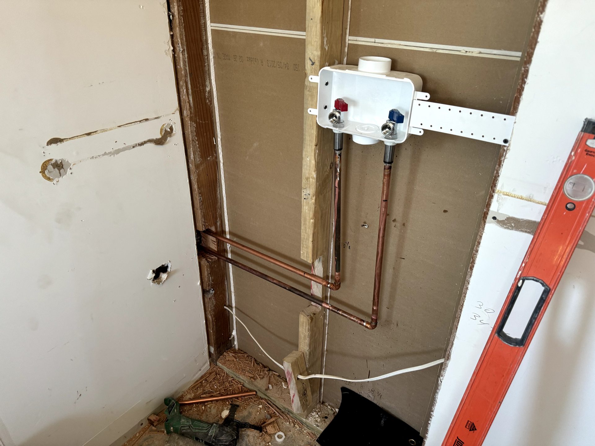 Recessed washer outlet box roughed in with copper supply valves and a drain standpipe in Phoenix