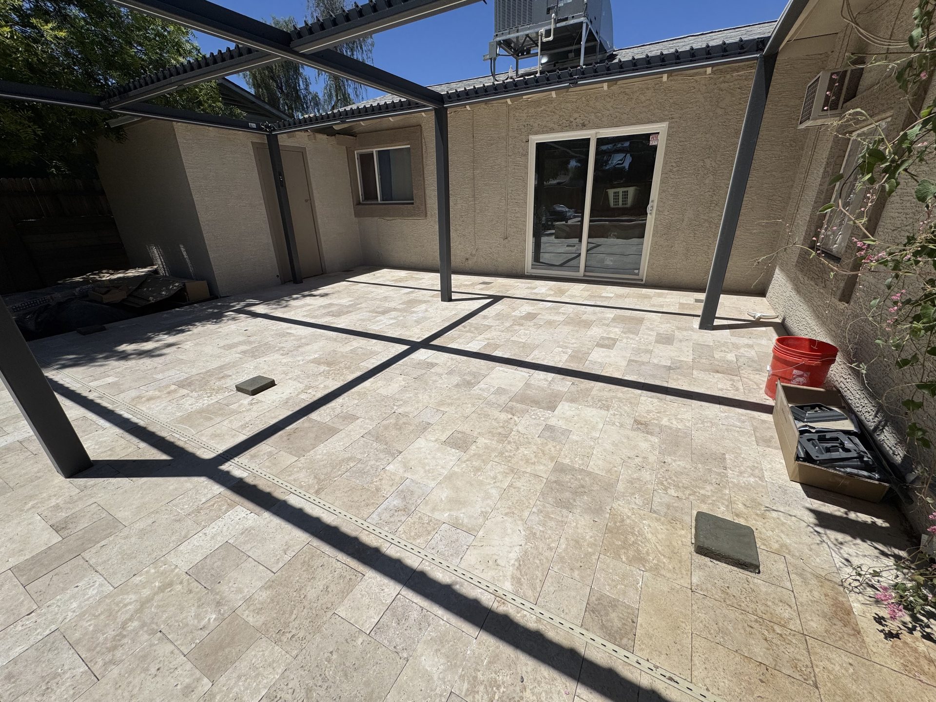 Aluminum pergola posts and frame set on a travertine paver patio in Phoenix