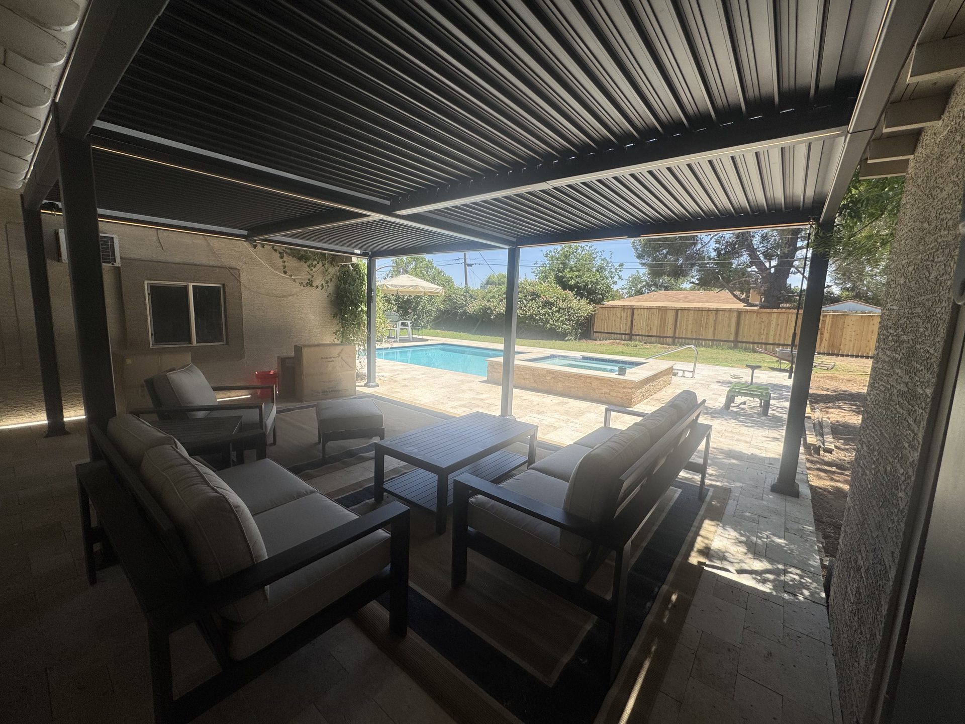 Finished louvered pergola shading a paver patio by a pool in Phoenix
