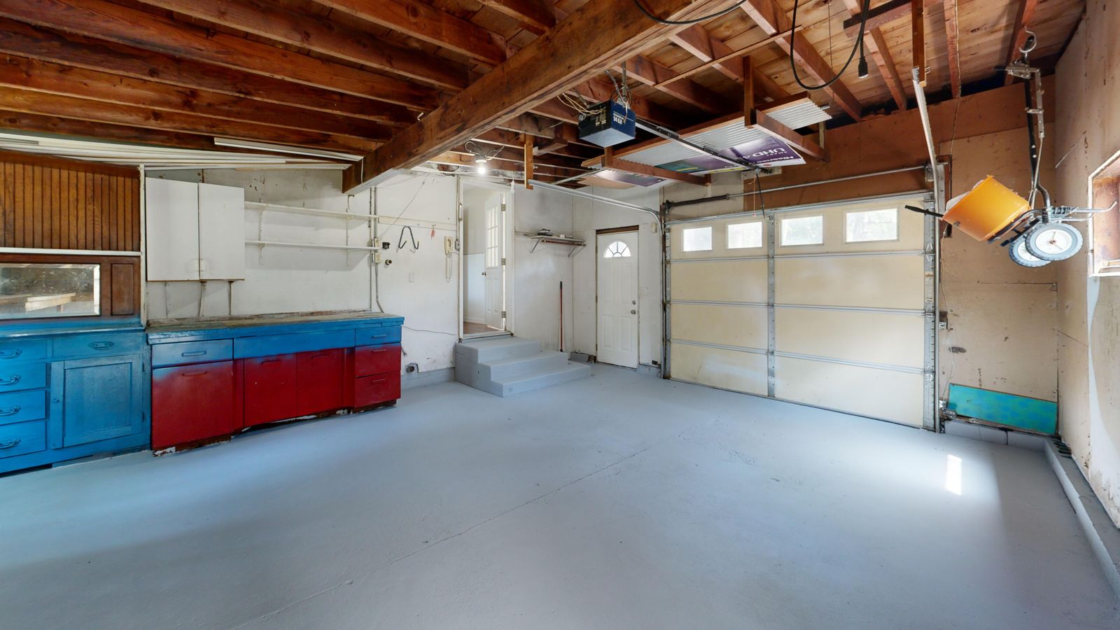 Older residential garage with a peeling painted concrete floor
