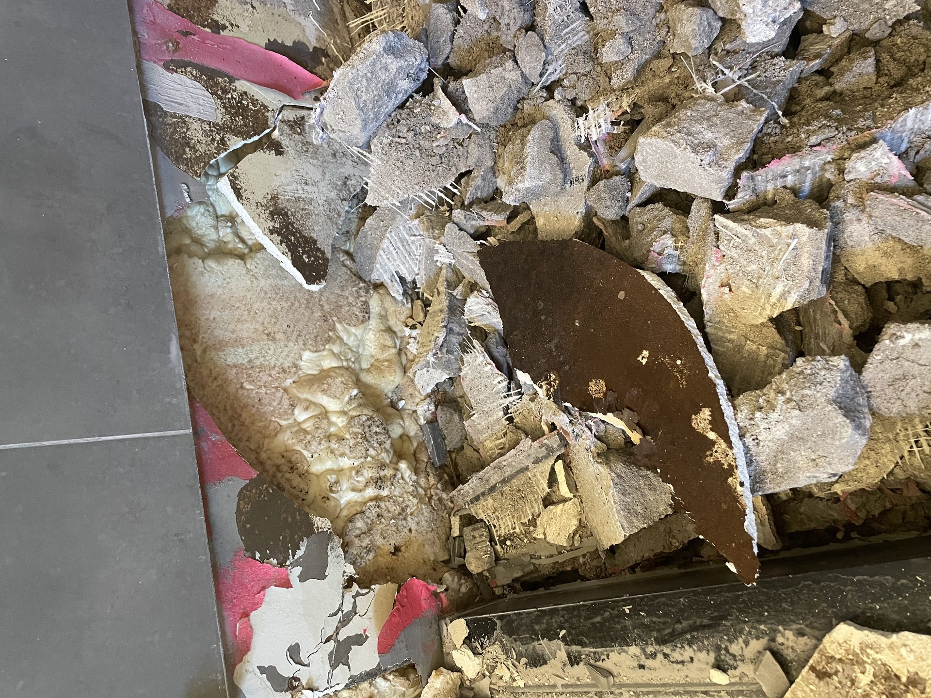 Tile and mortar demolition debris on the slab during a Phoenix bathroom tear-out