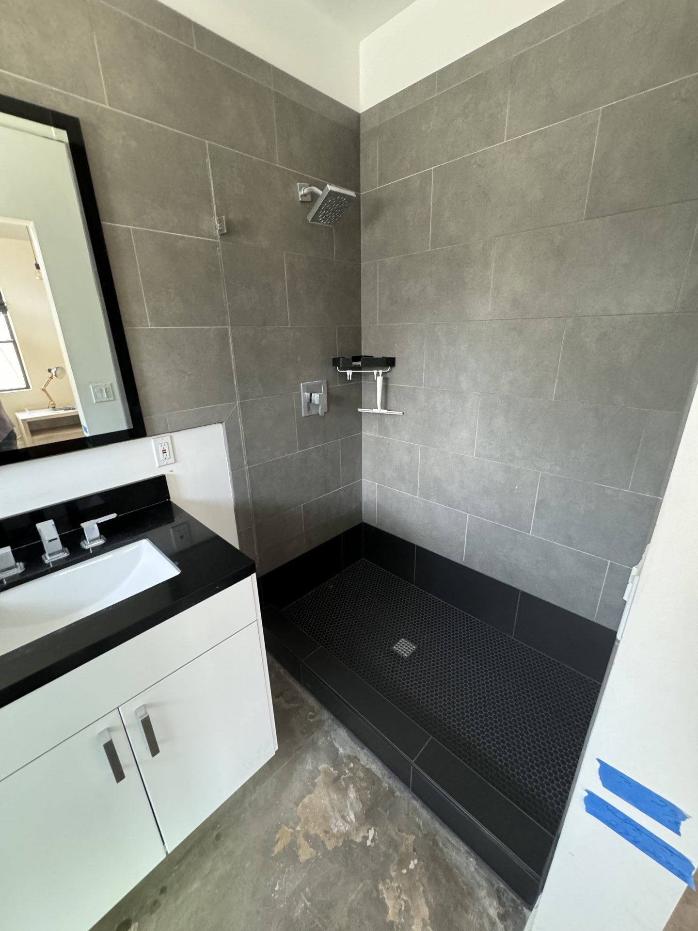 The rebuilt Phoenix shower: existing gray wall tile saved, new black pan and bottom course