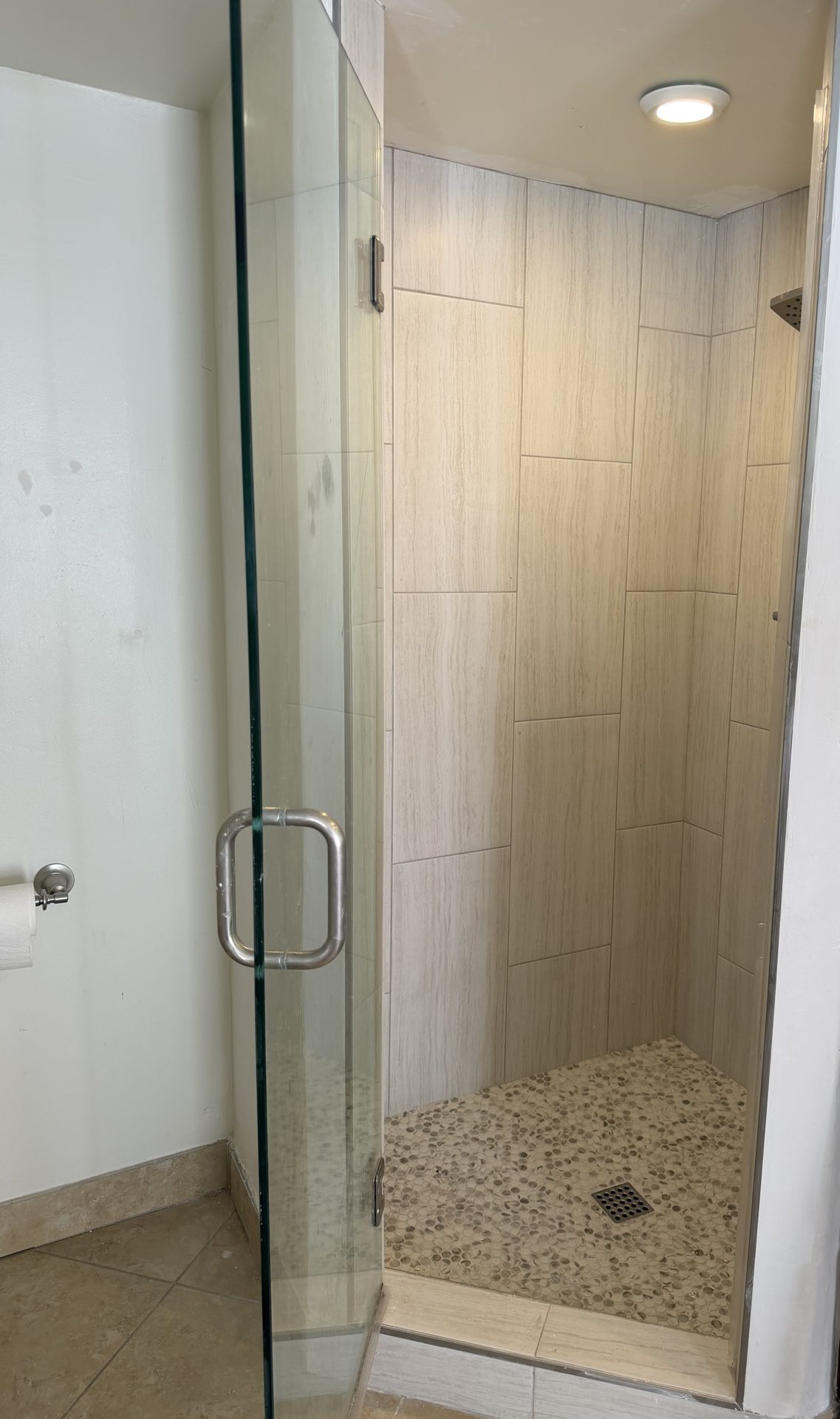 Finished tile shower rebuild with a frameless glass door and penny-round pan in a Scottsdale home