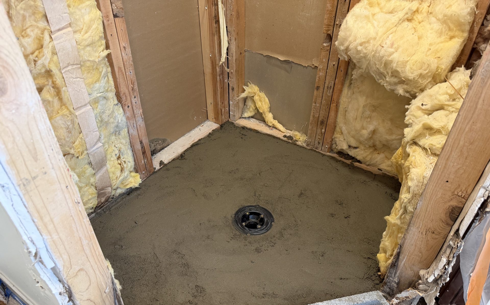 Mortar pre-slope floated to the clamping drain flange in a Scottsdale shower rebuild, the first of the two slopes in a mud-set pan
