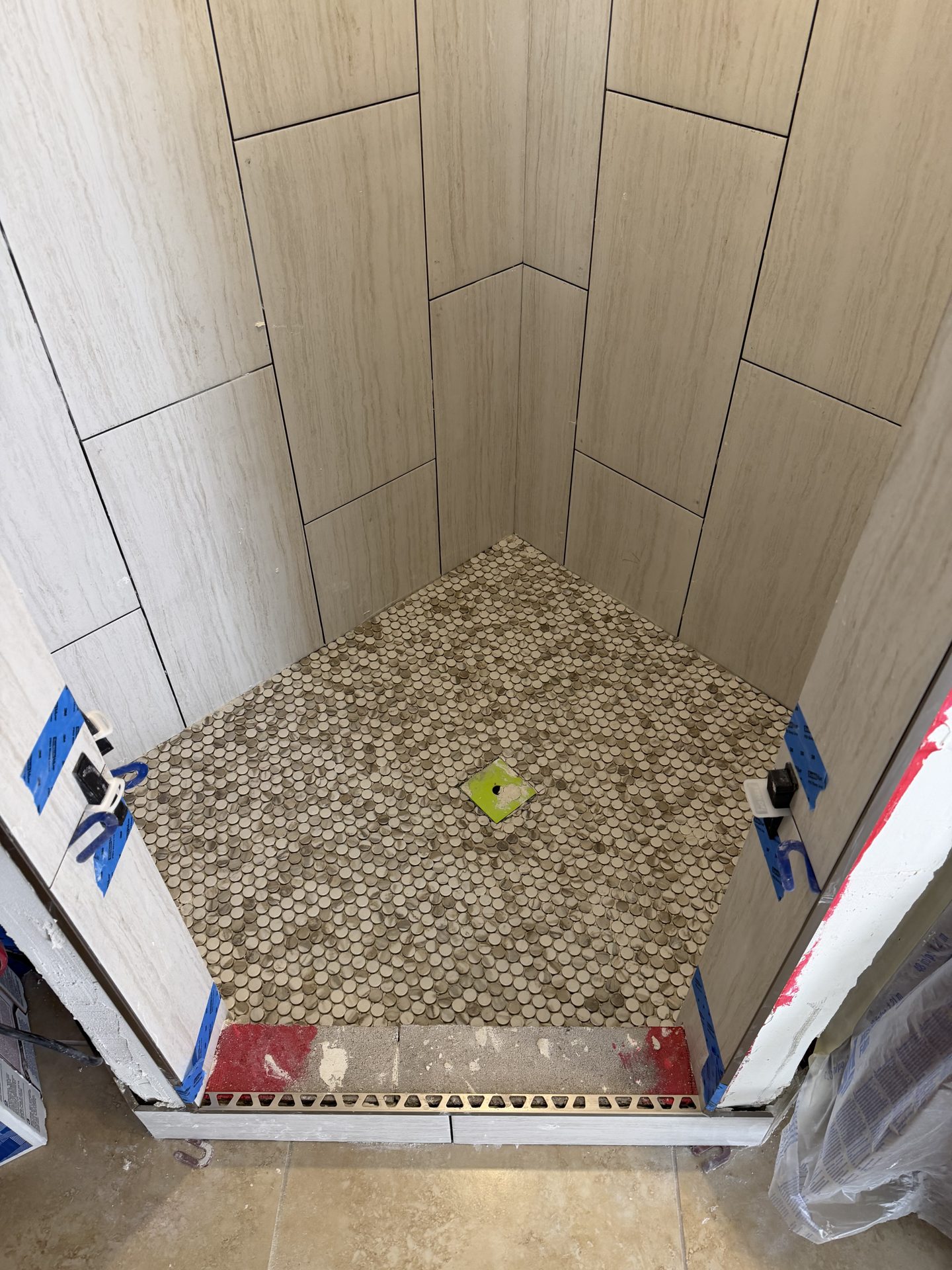 Large-format porcelain plank walls run vertically over a penny-round mosaic shower pan, McCormick Ranch master bath in Scottsdale