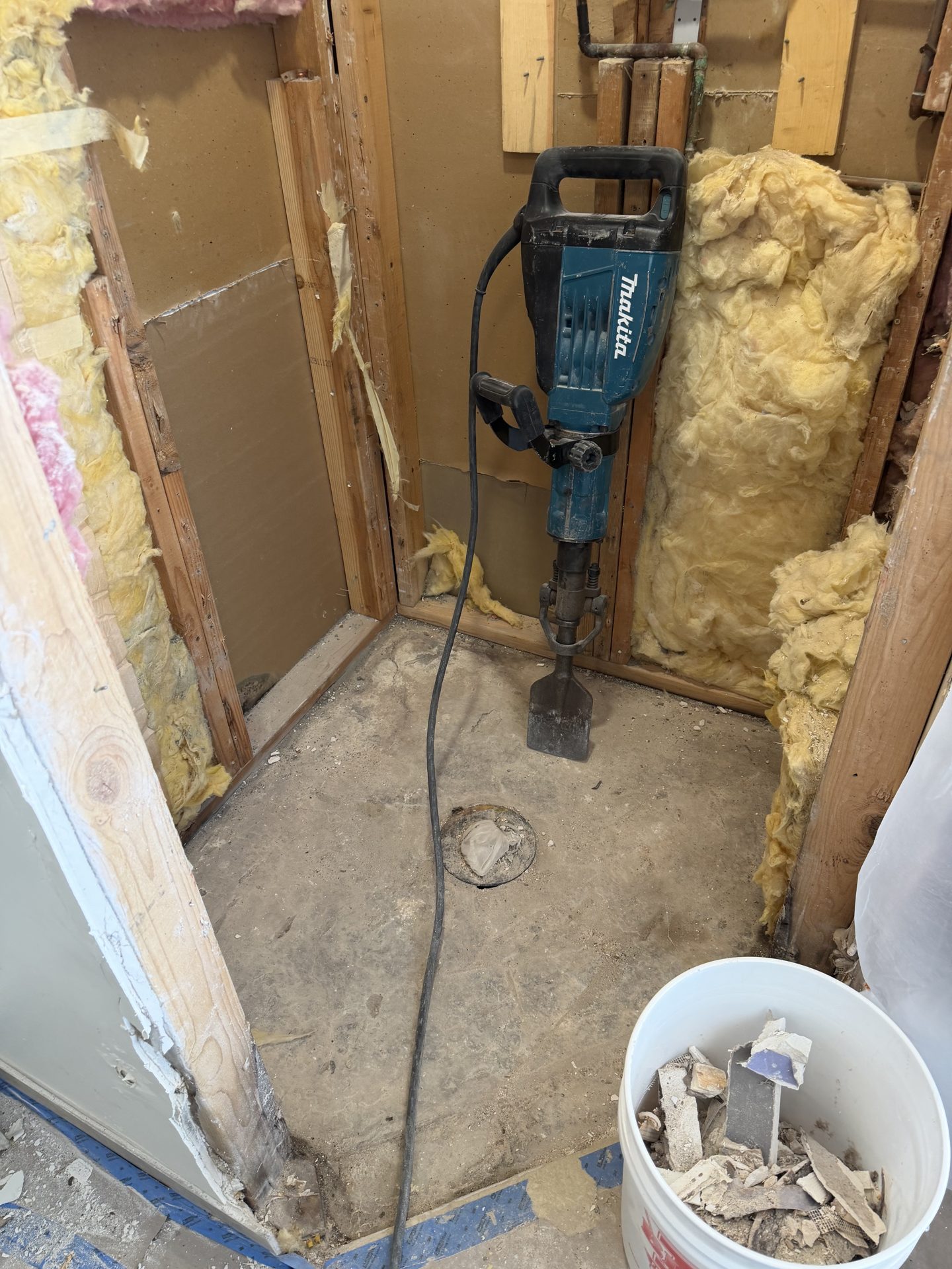 Shower stripped to the bare concrete slab with the drain riser capped, before the new pan is built, Scottsdale AZ