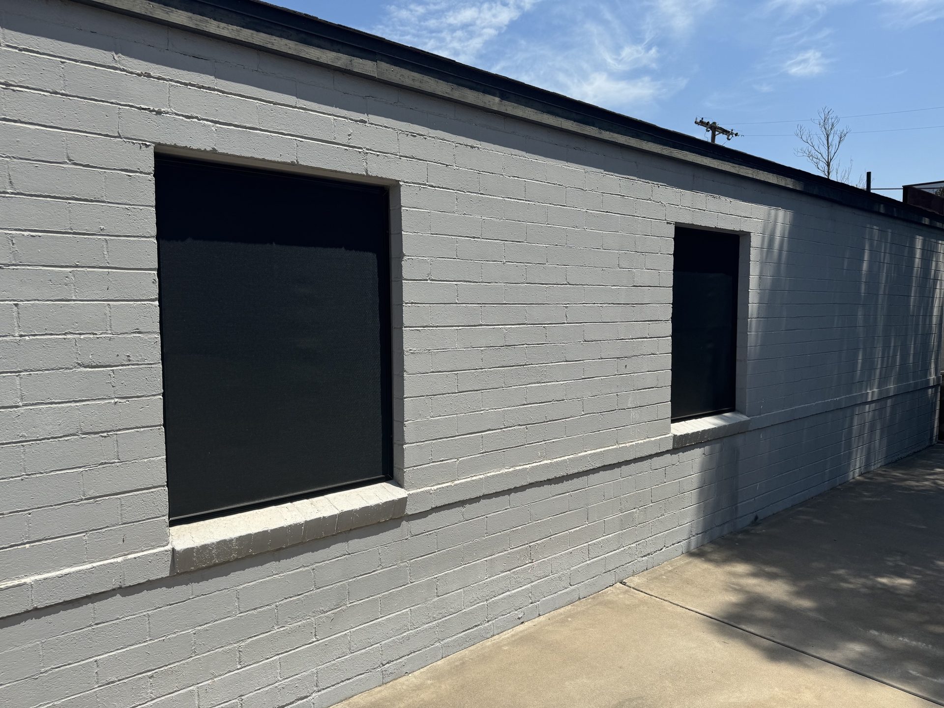 Full-blockage solar screens installed on driveway-facing windows of a Phoenix property