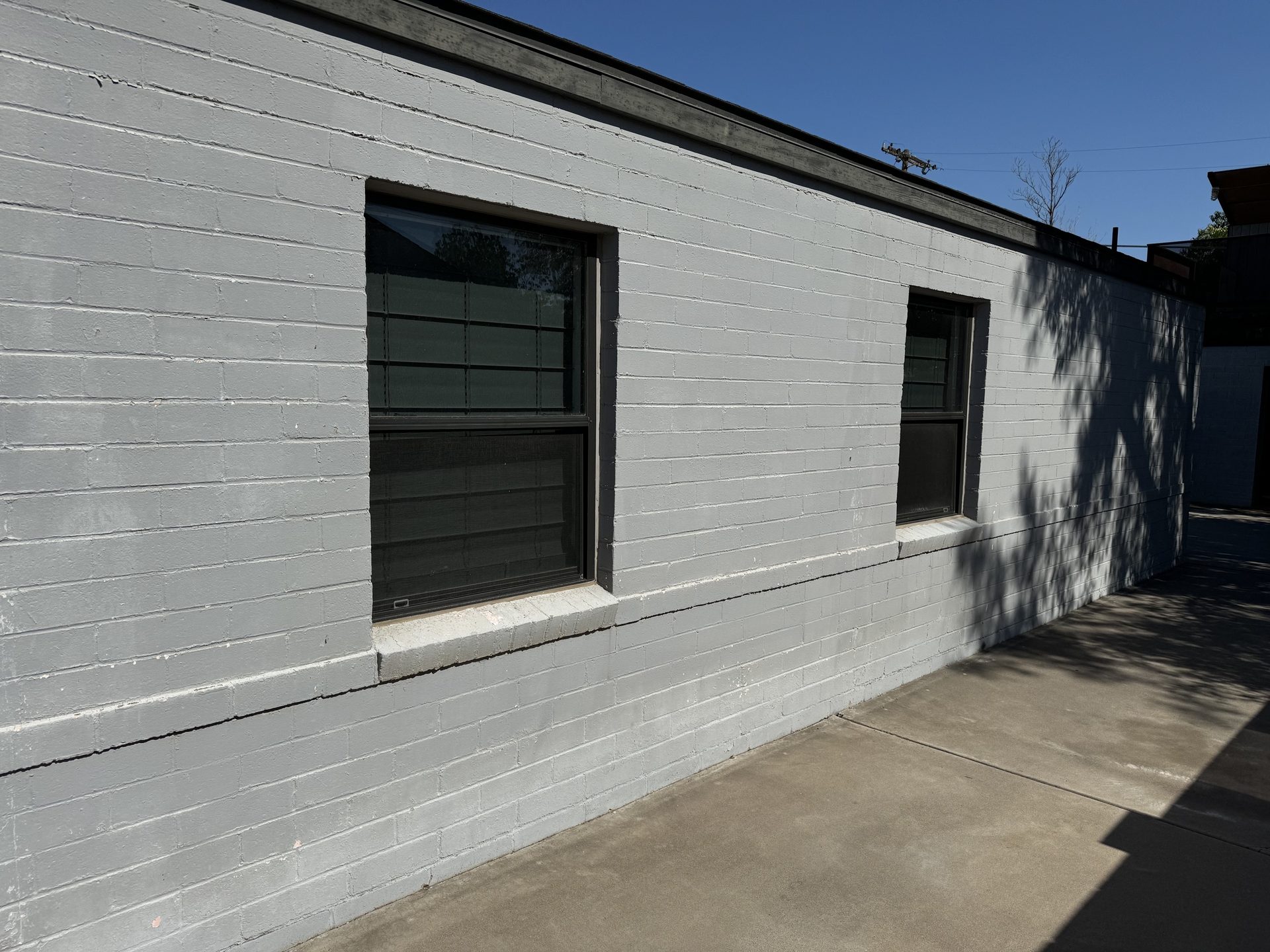 Driveway-facing windows before solar screens, bare glass in full Phoenix sun