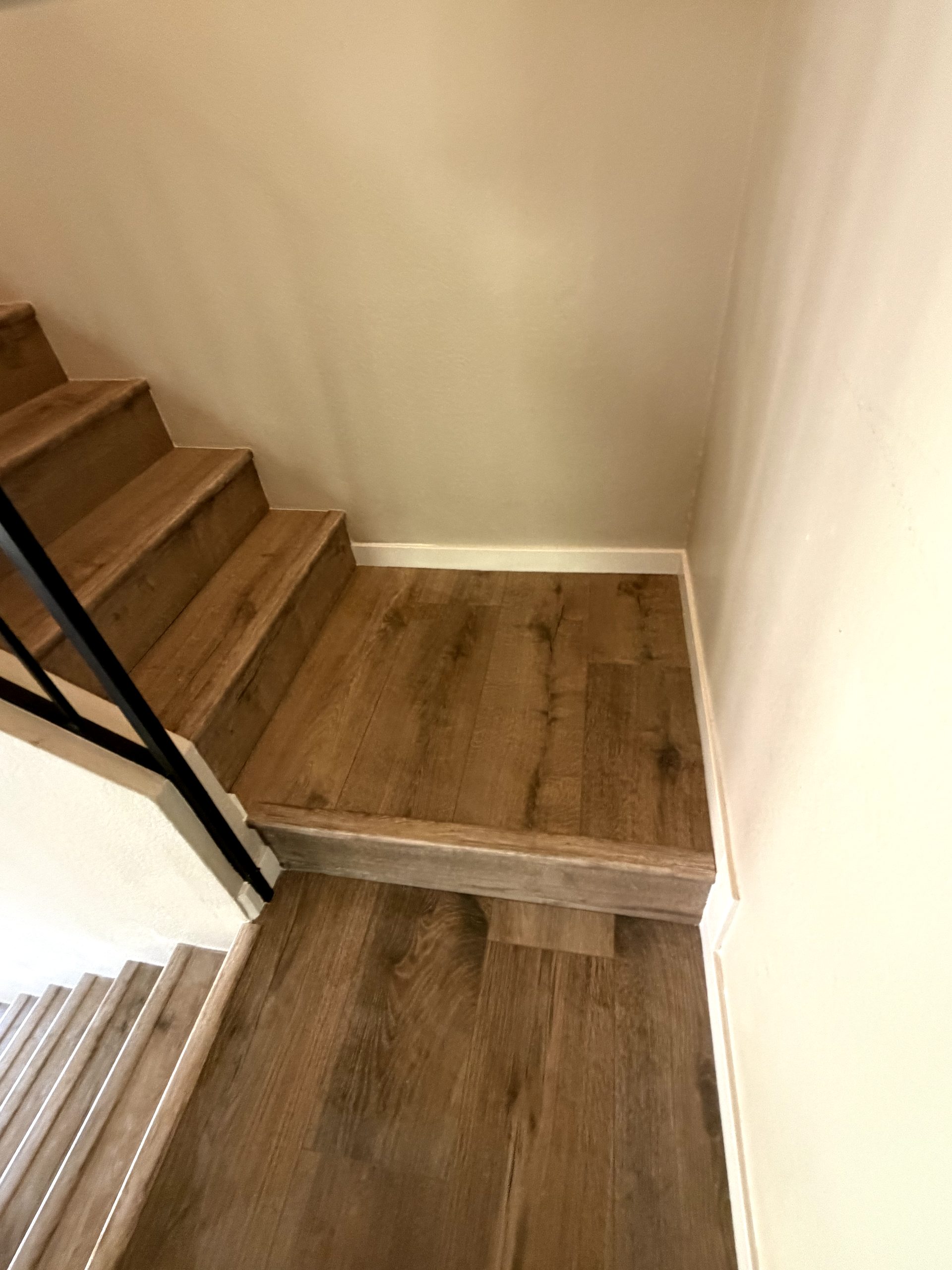 After: finished vinyl plank stair landing with new baseboards Phoenix AZ