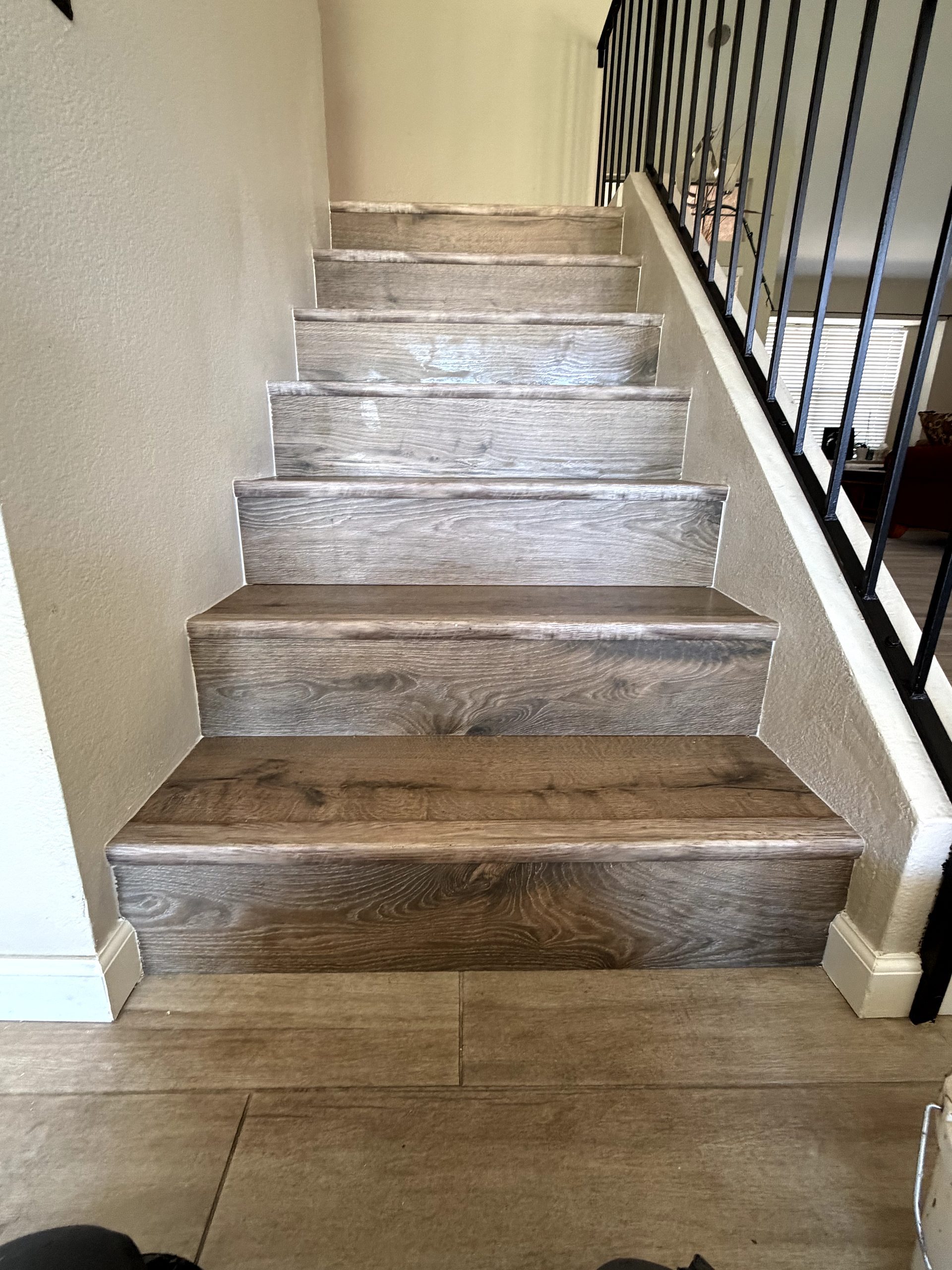 After: carpet-to-vinyl-plank stair conversion with black stair railing Phoenix AZ