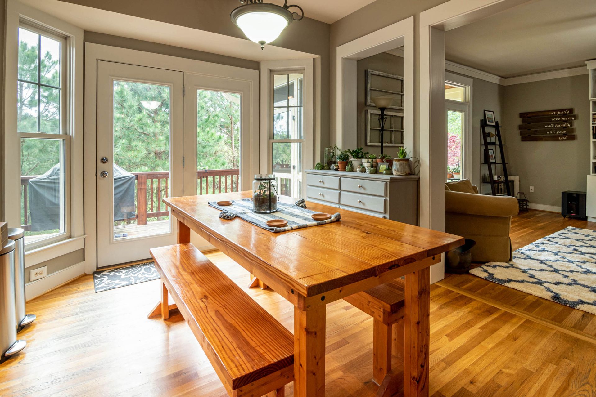 A pair of white-framed full-lite French doors leading from a breakfast nook out to a wooden deck